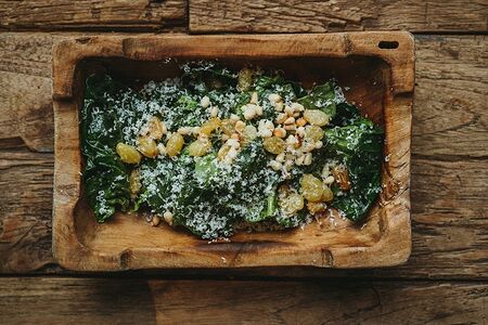 Шпинат с пармезаном, кедровым орехом и изюмом