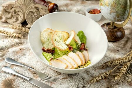 Цезарь с филе цыпленка, обжаренным в хоспере, и вялеными томатами