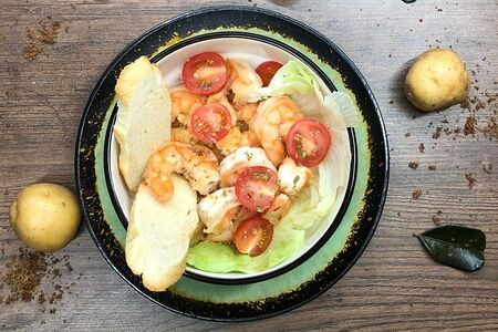 Тигровые креветки, обжаренные в чесночном масле. Подаются с  помидорами черри и зелёным салатом