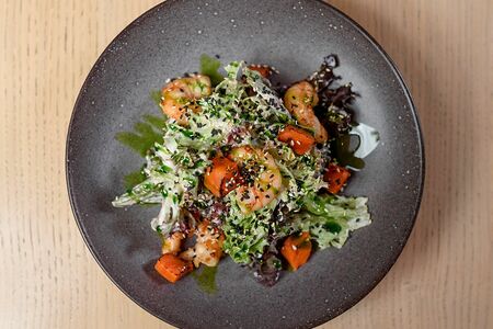 Салат с королевскими креветками, кокосовой заправкой и печёной тыквой