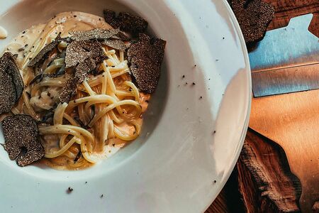 Сливочная паста с черным трюфелем готовится в головке пармезана