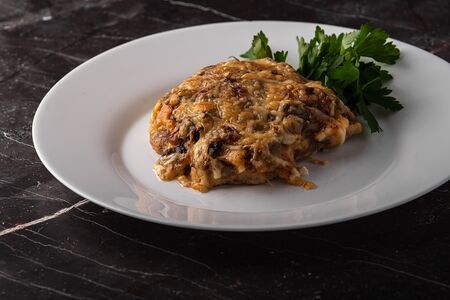 Свинина, запеченная под грибами и сыром