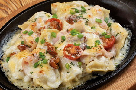 Домашние пельмени, запеченные под сливочным соусом с ветчиной и опятами