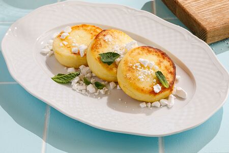 Сырники со сметаной и меренговой крошкой 