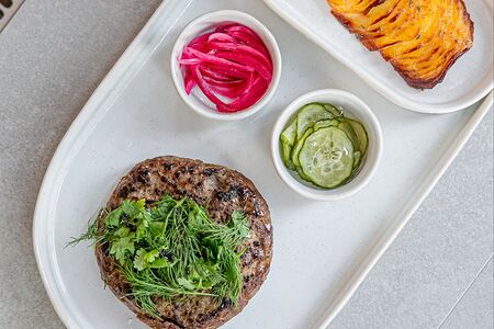 Большая котлета с маринованным луком и огурцами