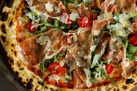 Пицца с прошутто крудо, рукколой и пармиджиано