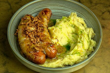 Свиные колбаски и картофельное пюре с карамелизированным луком