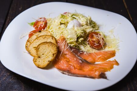 Цезарь с лососем и перепелиным яйцом пашот