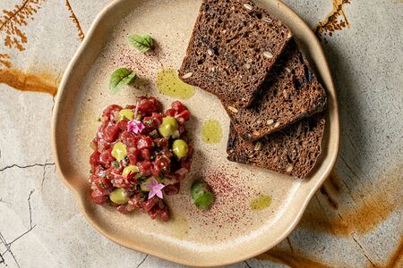 Тартар из мраморной говядины с кремом из трав и релишем из огурца