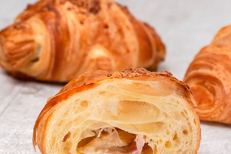 Свежеиспеченный круассан с ветчиной и сыром