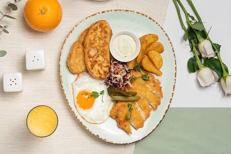 Завтрак с яичницей, куриным шницелем и картофельными дольками