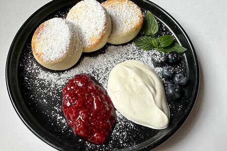 Три сырника с малиной и сметаной