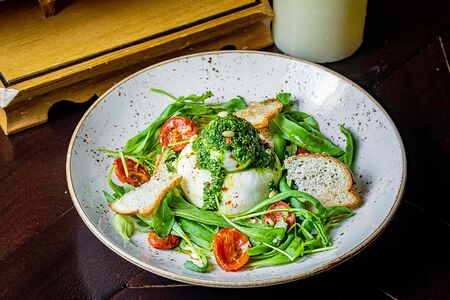 Буррата с томатами конфи, руколой, соусом песто и греческой заправкой