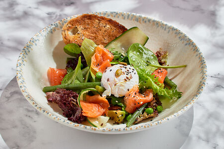 Зеленый овощной салат с лососем, яйцом пашот и зерновым тостом