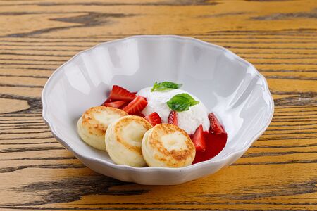 Сырники из рикотты с клубникой и сметанным кремом