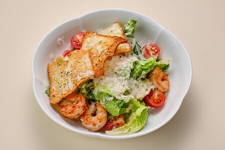 Листья салата с креветками, сыром Грюйер, пшеничными крутонами и рыбным соусом