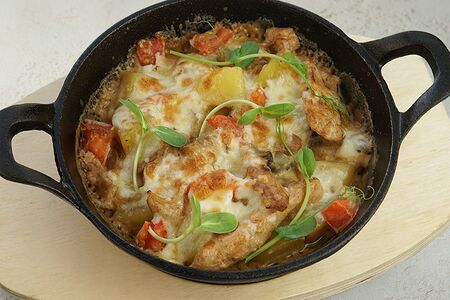 Горячая сковородка с куриной грудкой под сырной шапкой