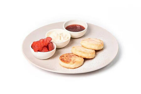 Домашние сырники с фирменным кремом и сезонными ягодами