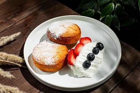 Домашние сырники с ягодой и сметаной