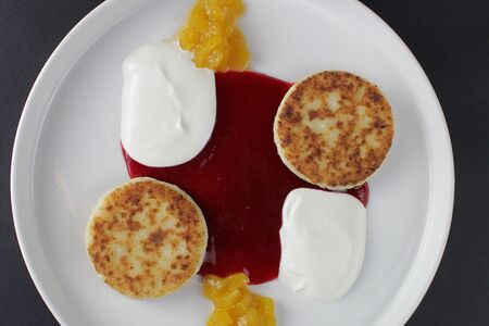 Сырники из творога с малиновым соусом и сметаной