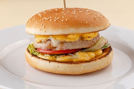 Бургер с котлетой из цыпленка, моцареллой, свежими овощами и сырным соусом