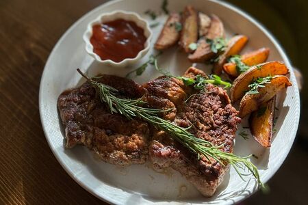 Стейк cвинoй с картофелем и соусом BBQ